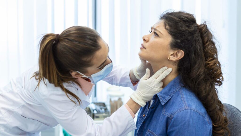 Lymphoma Treatment in Thrissur Kerala doctor examining swollen lymph nodes in patient during consultation