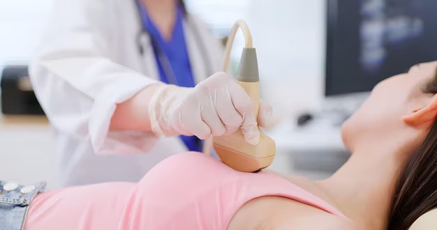 Doctor performing an ultrasound scan for breast cancer treatment cost evaluation in a modern clinical diagnostic setting.